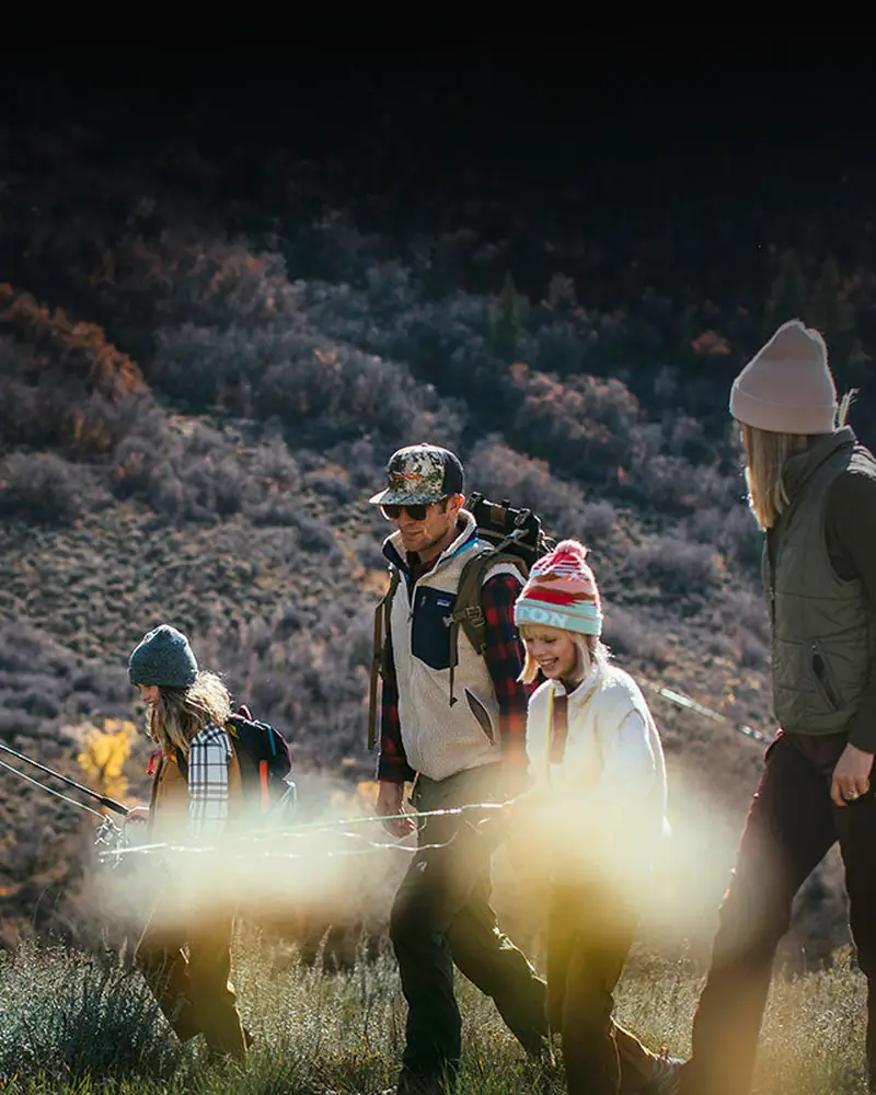 Hikers crossing a snowy ridge at dusk